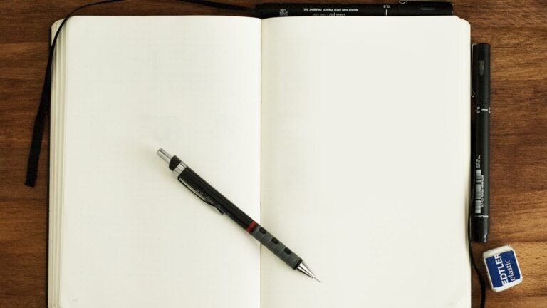Persoană scriind un brief într-un caiet la birou